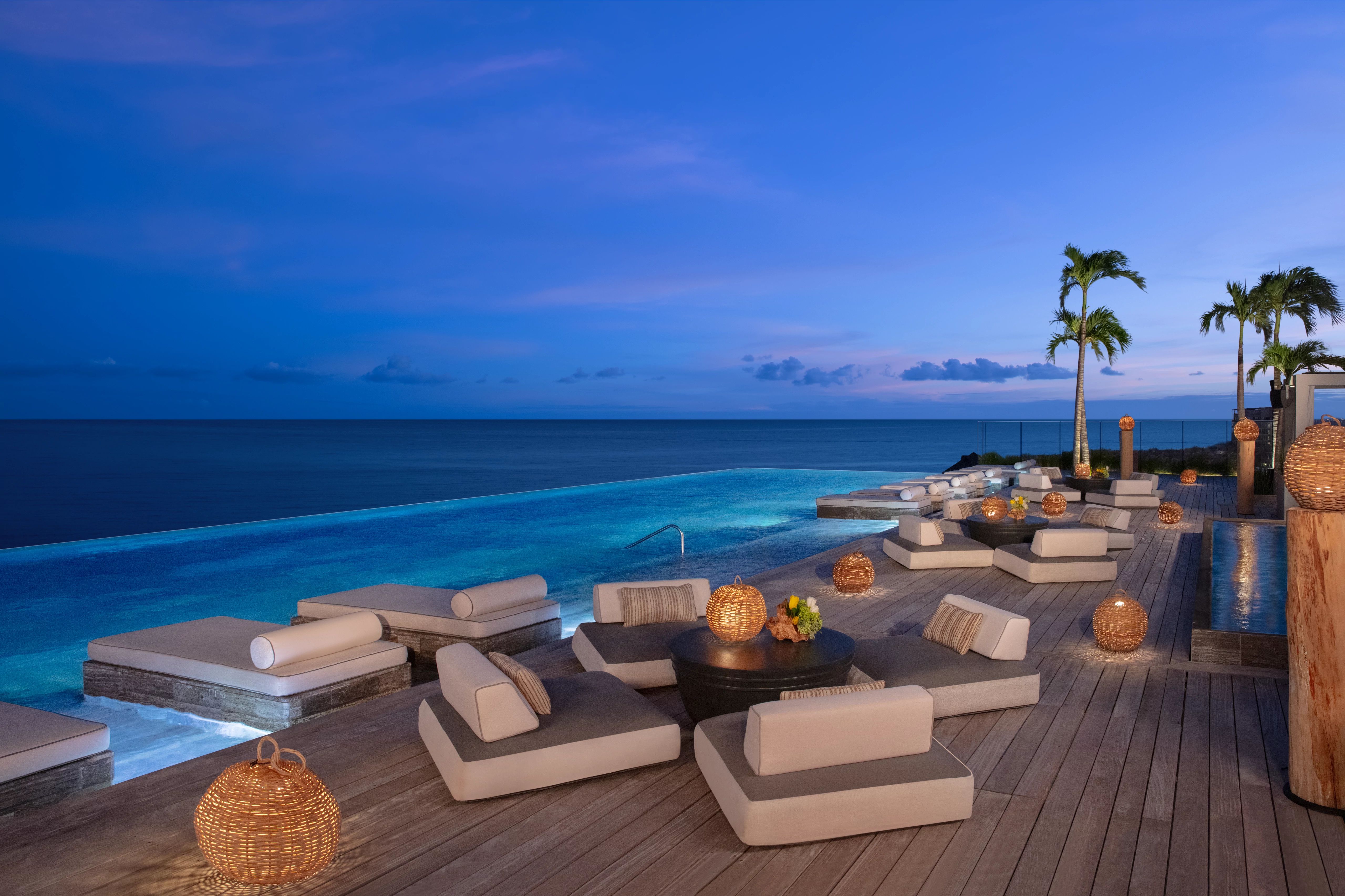 Group enjoying rooftop cocktails and socializing at a luxury travel destination with scenic views